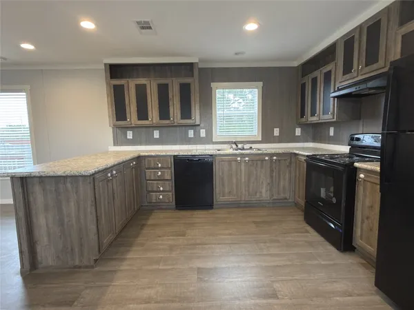 a kitchen with stainless steel appliances granite countertop a stove a sink dishwasher and a refrigerator