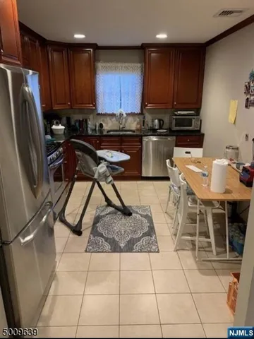 a kitchen with stainless steel appliances granite countertop a stove a sink a microwave and a refrigerator