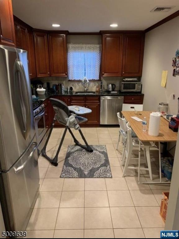 26 Sampson Street, Unit 1 Garfield, NJ 07026 - Photo 4 of 12 a kitchen with stainless steel appliances granite countertop a stove a sink a microwave and a refrigerator