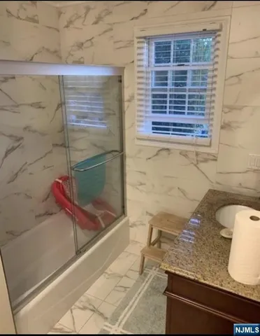 a bathroom with a granite countertop sink and a mirror