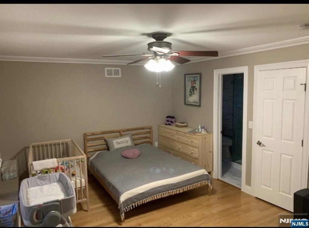 26 Sampson Street, Unit 1 Garfield, NJ 07026 - Photo 8 of 12 a bedroom with a bed and a chandelier