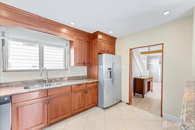 a kitchen with stainless steel appliances granite countertop a refrigerator and a sink