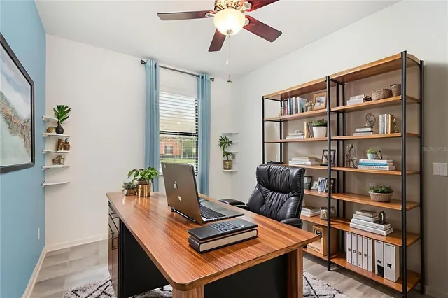 a view of a workspace with furniture and a book shelf