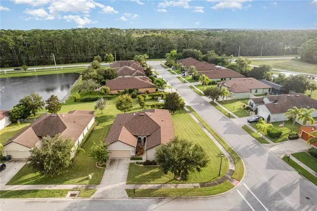 an aerial view of residential houses with outdoor space and lake view