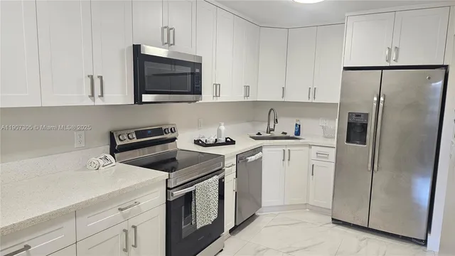 a kitchen with white cabinets and stainless steel appliances