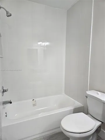 a white toilet and tub sitting next to a bathroom sink
