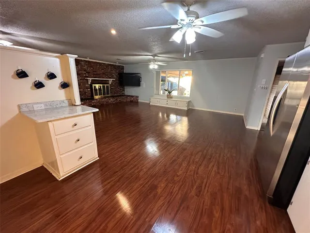 a view of a hallway with wooden floor and a ceiling fan