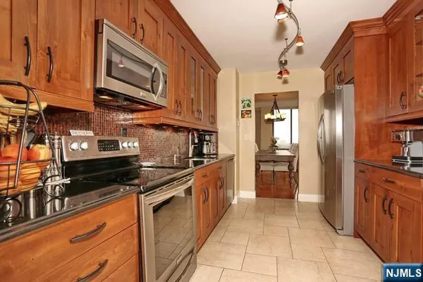 a kitchen with stainless steel appliances granite countertop a stove and a refrigerator