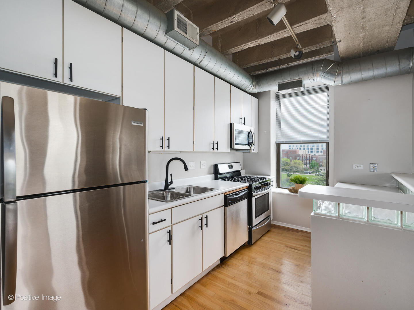 811 South Lytle Street, Unit 303 Chicago, IL 60607 - Photo 4 of 17 a kitchen with a refrigerator a sink and cabinets