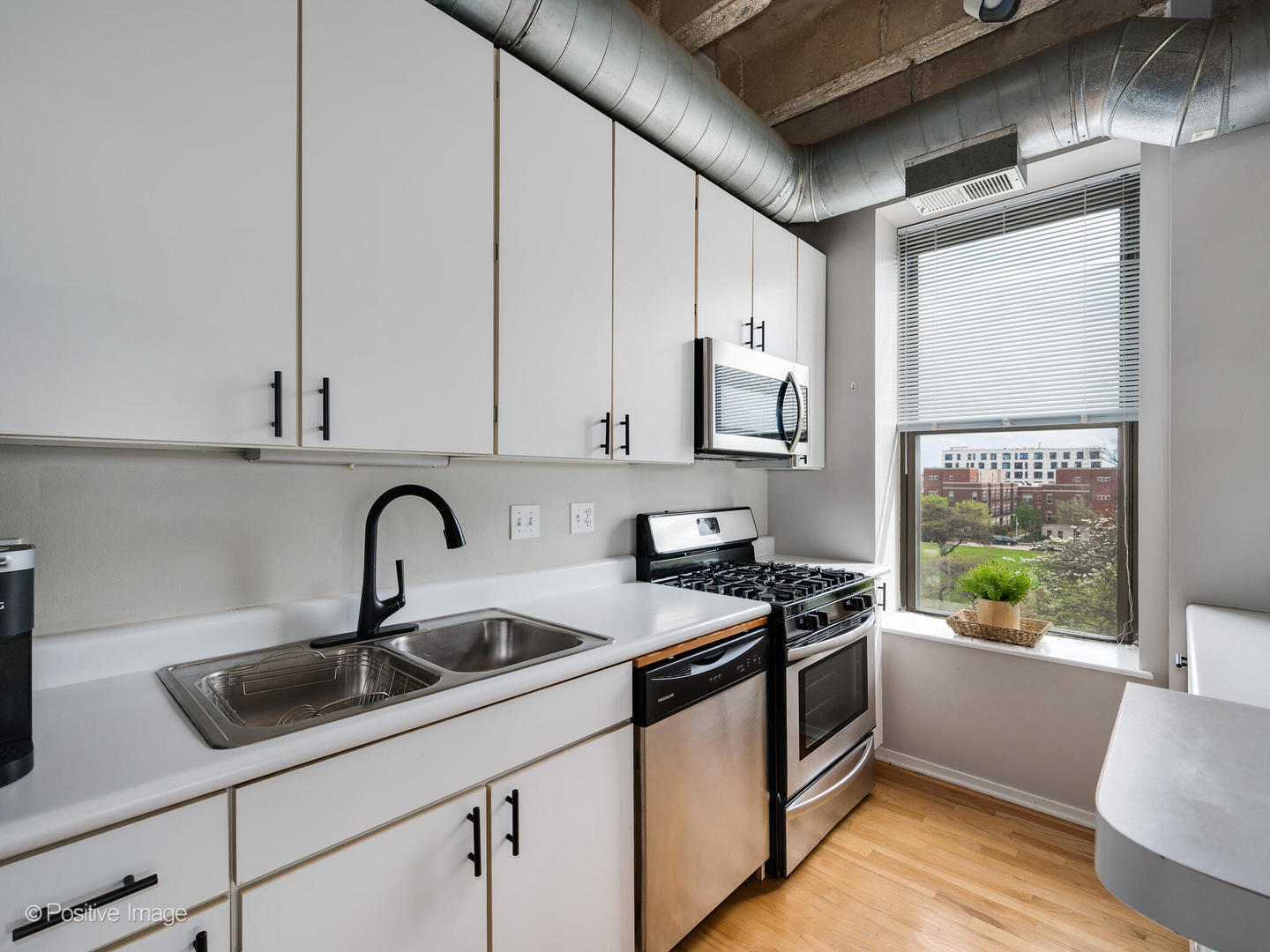811 South Lytle Street, Unit 303 Chicago, IL 60607 - Photo 5 of 17 a kitchen with stainless steel appliances a sink a stove a microwave a sink and cabinets