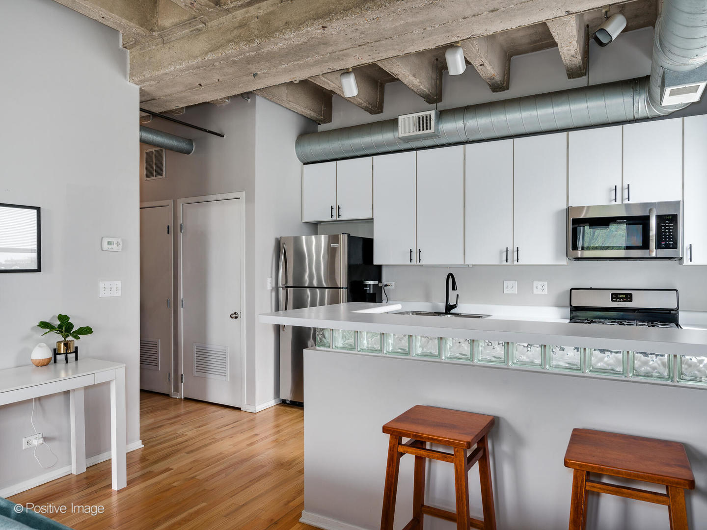 811 South Lytle Street, Unit 303 Chicago, IL 60607 - Photo 6 of 17 a kitchen with stainless steel appliances granite countertop a refrigerator a sink dishwasher a stove and white countertops with wooden floor