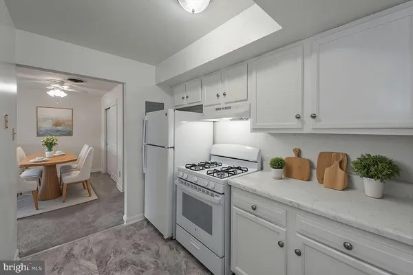 a kitchen with white cabinets and white appliances