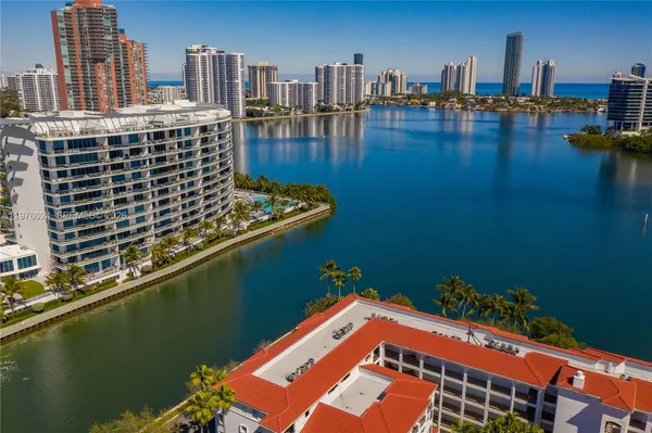 a living room with furniture a flat screen tv and a refrigerator