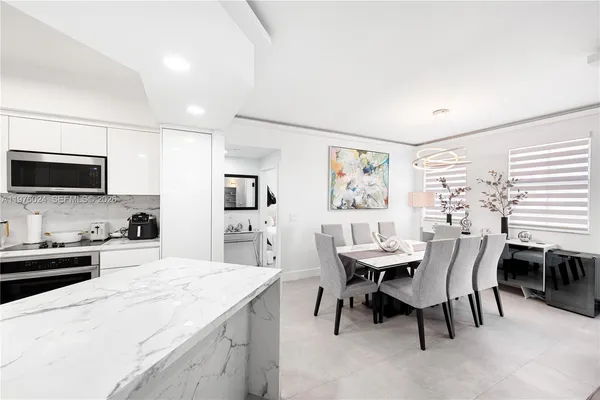 a kitchen with a sink stainless steel appliances and white cabinets