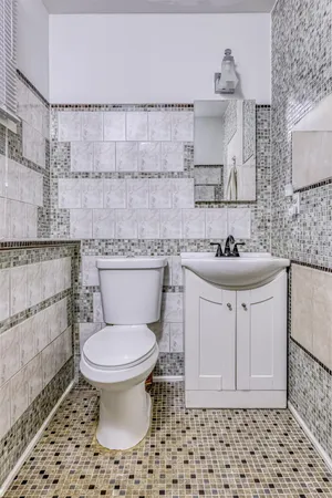 a bathroom with a sink toilet and a mirror