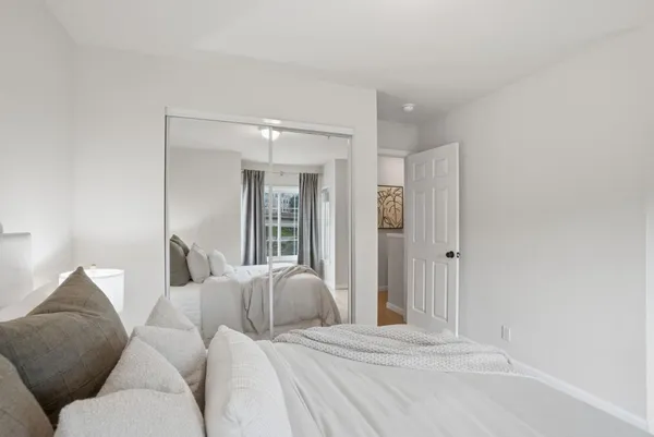 a view of a room that has a bed and a mirror in it