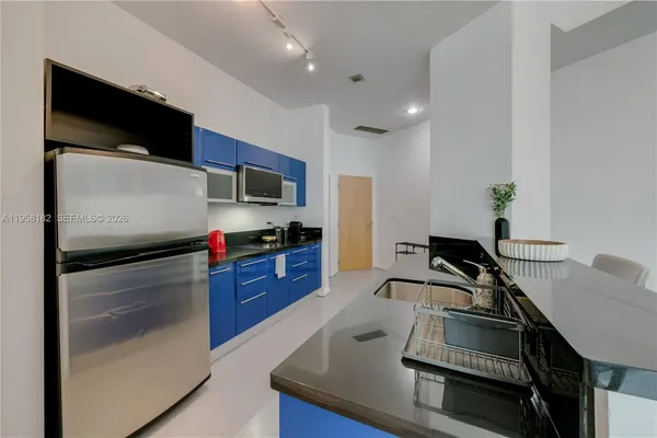 a kitchen with kitchen island a counter top space appliances and cabinets