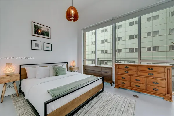 a bedroom with a bed and a large window