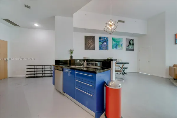 a kitchen with stainless steel appliances granite countertop a stove a sink dishwasher and a dining table with the kitchen view