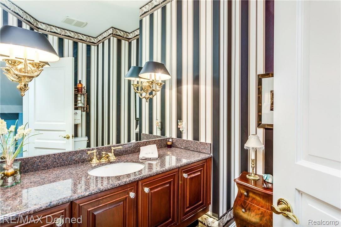 585 Whims Lane Rochester, MI 48306 - Photo 14 of 30 The lav is beautifully decorated and features a floating vanity and granite counter top.