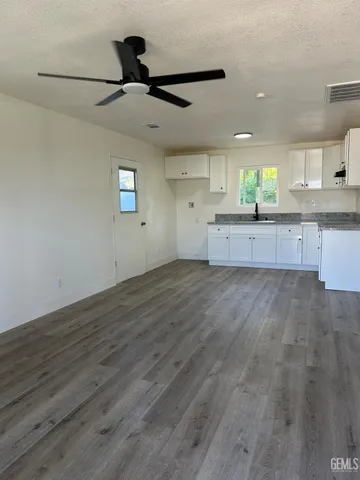 a large kitchen with cabinets wooden floor and a ceiling fan