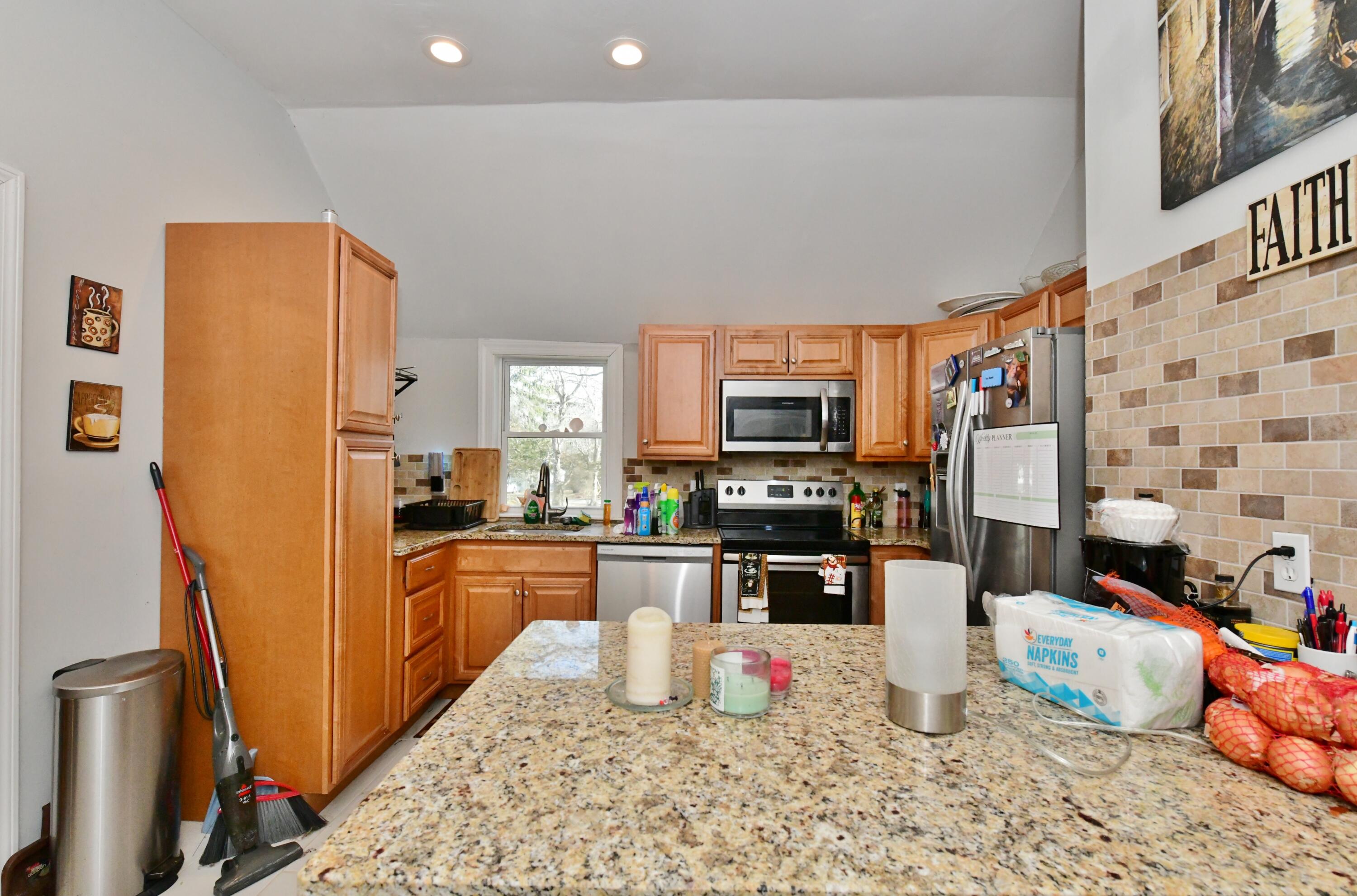 26 Old Monument Neck Road Bourne, MA 02532 - Photo 18 of 51 a kitchen with stainless steel appliances granite countertop a refrigerator stove top oven a sink and dishwasher