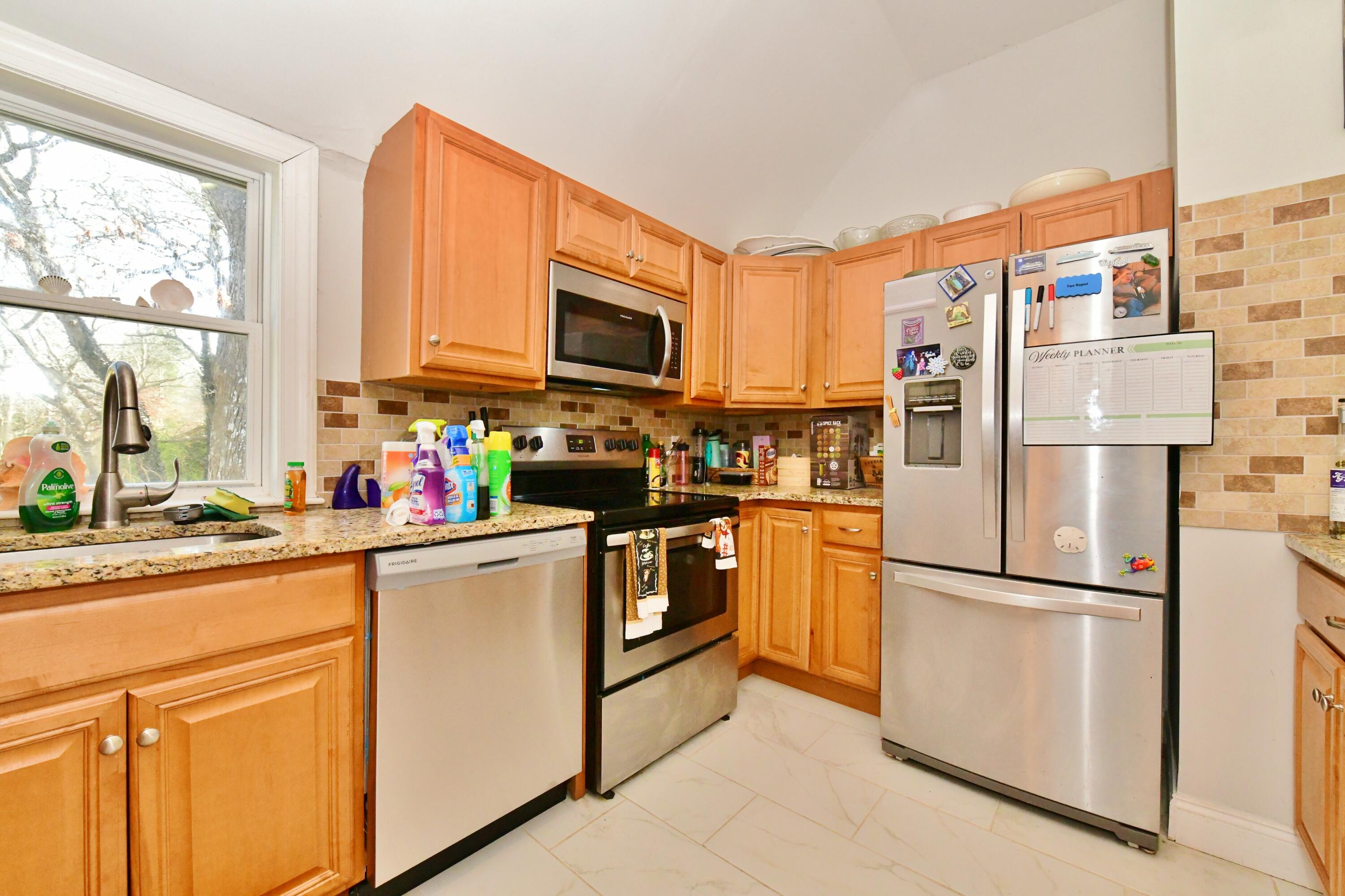 26 Old Monument Neck Road Bourne, MA 02532 - Photo 19 of 51 a kitchen with stainless steel appliances granite countertop a refrigerator stove microwave and sink