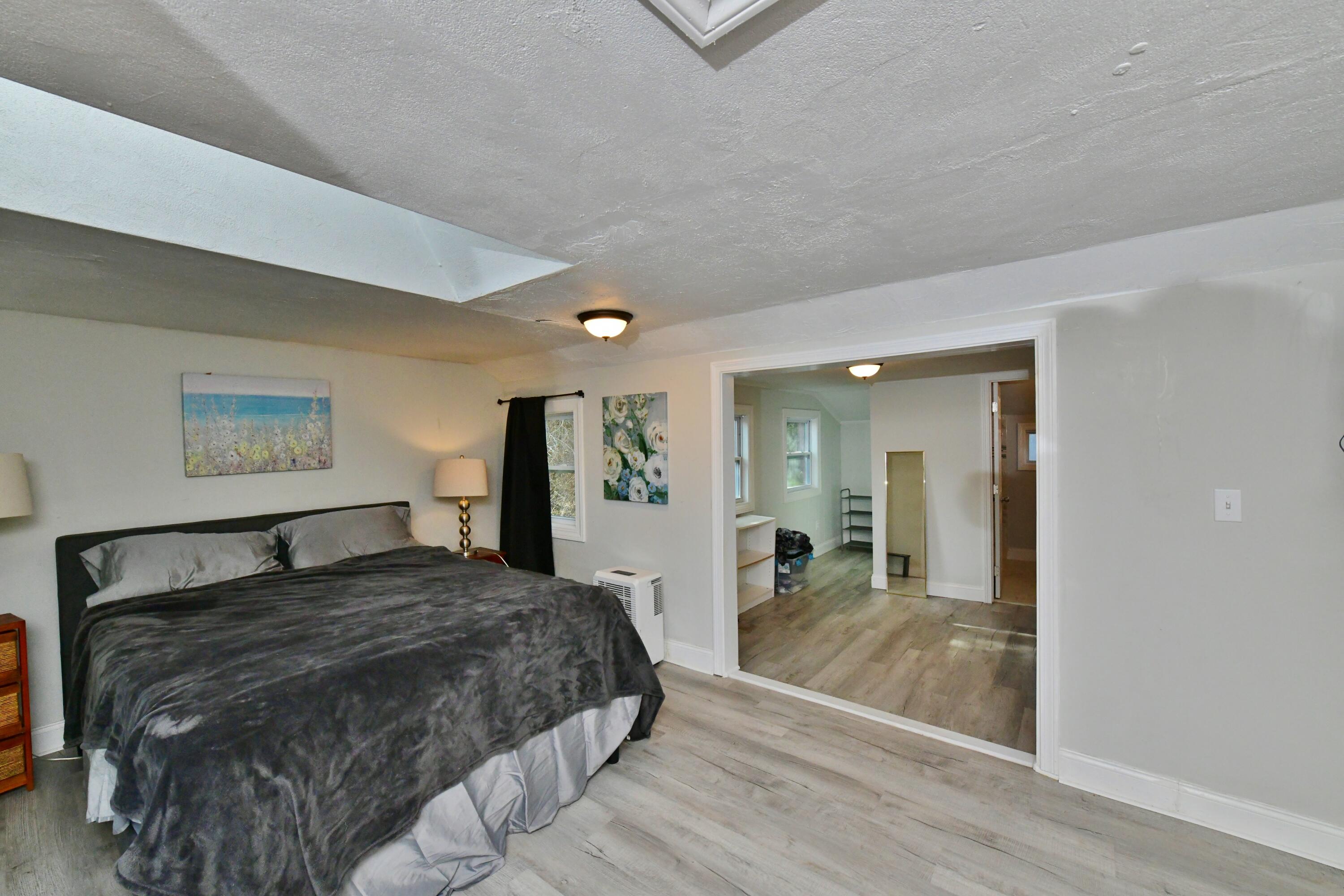 26 Old Monument Neck Road Bourne, MA 02532 - Photo 30 of 51 a bedroom with a large bed and a chandelier