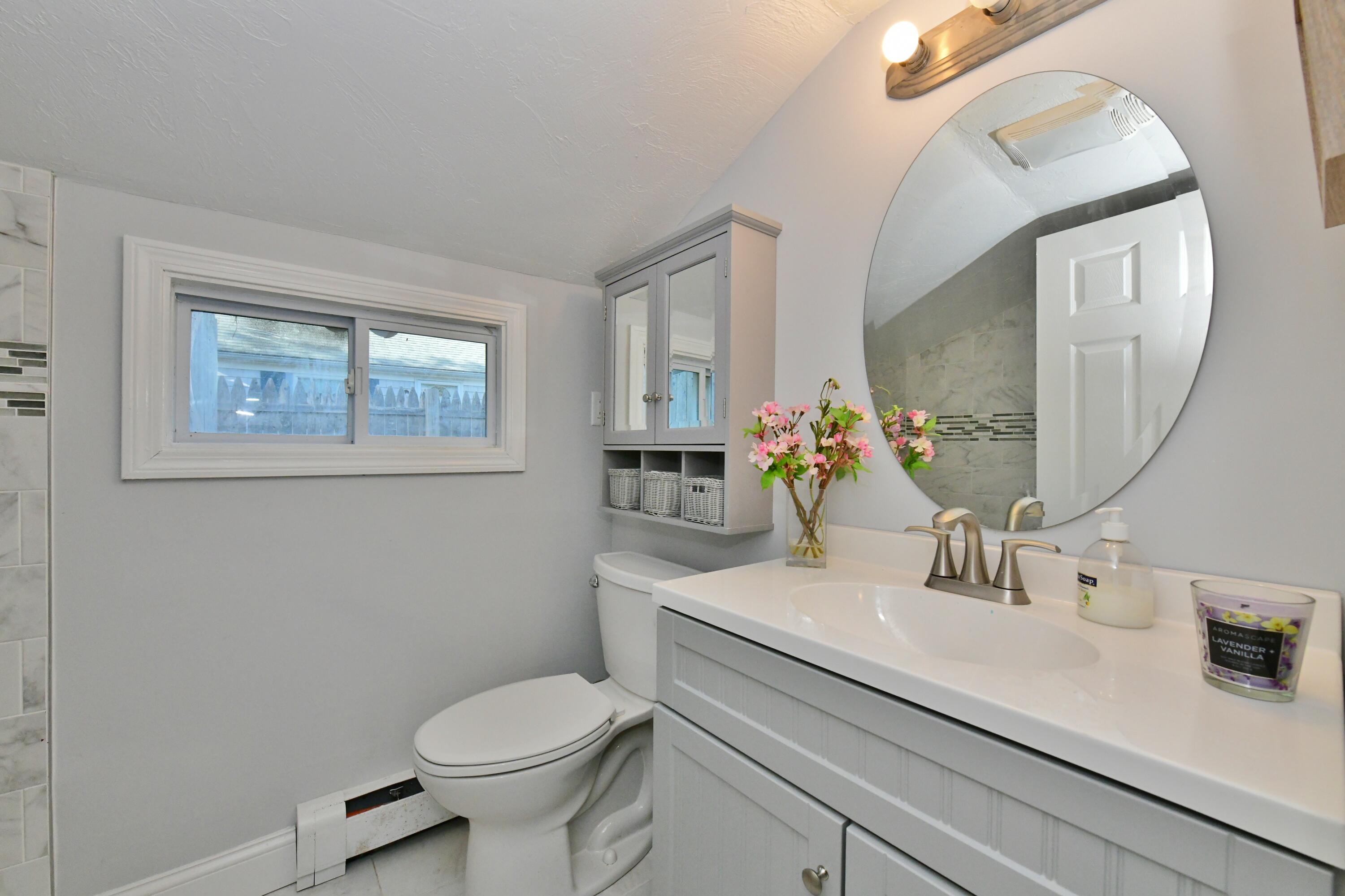 26 Old Monument Neck Road Bourne, MA 02532 - Photo 36 of 51 a bathroom with a toilet a sink and mirror