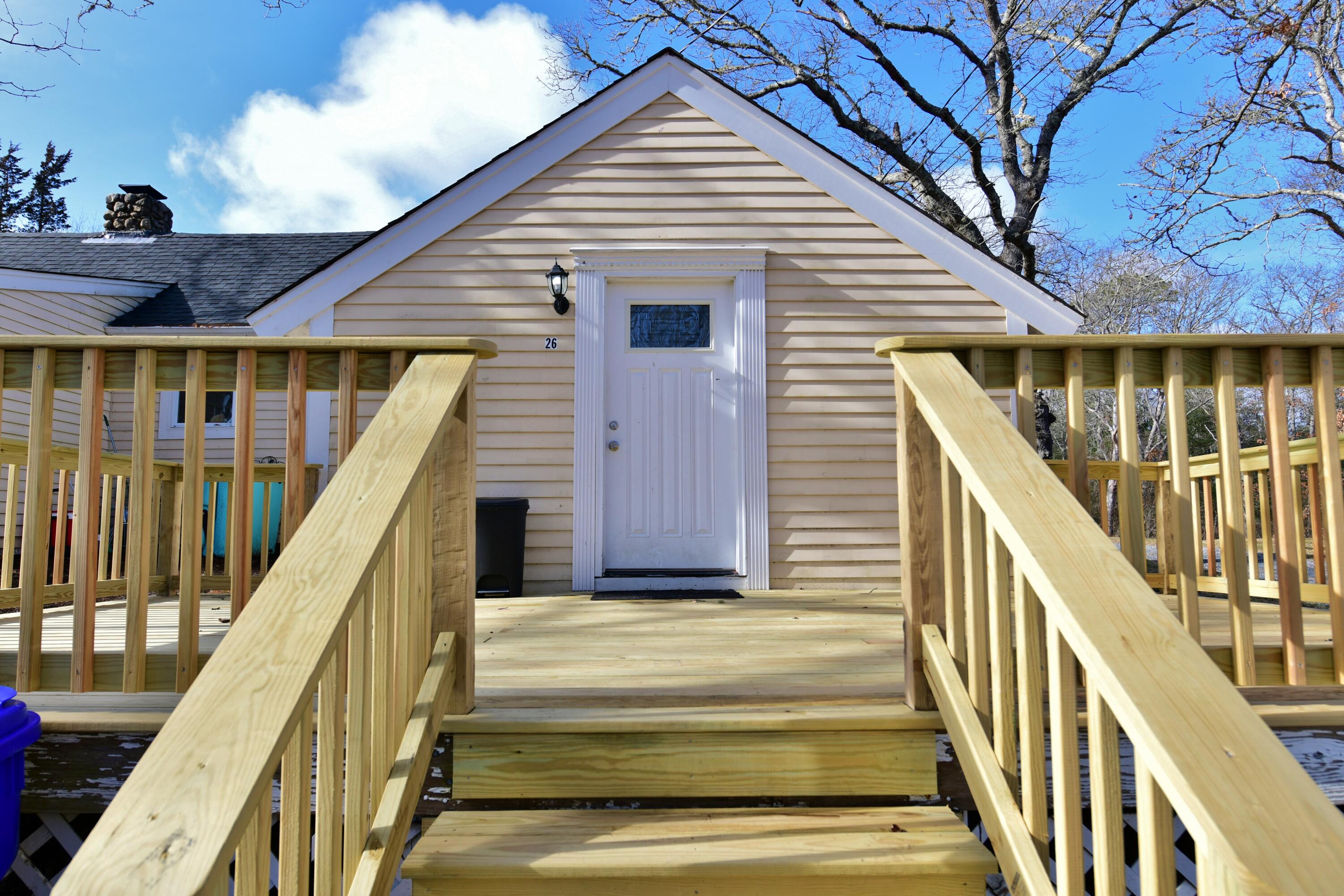 26 Old Monument Neck Road Bourne, MA 02532 - Photo 4 of 51 a view of a house with wooden stairs and deck