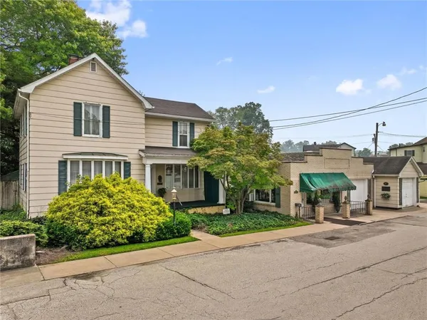 a front view of a house with a garden and plants