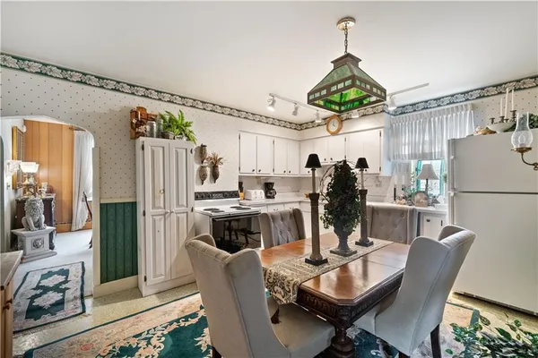 a kitchen with stainless steel appliances granite countertop a refrigerator dining table and chairs