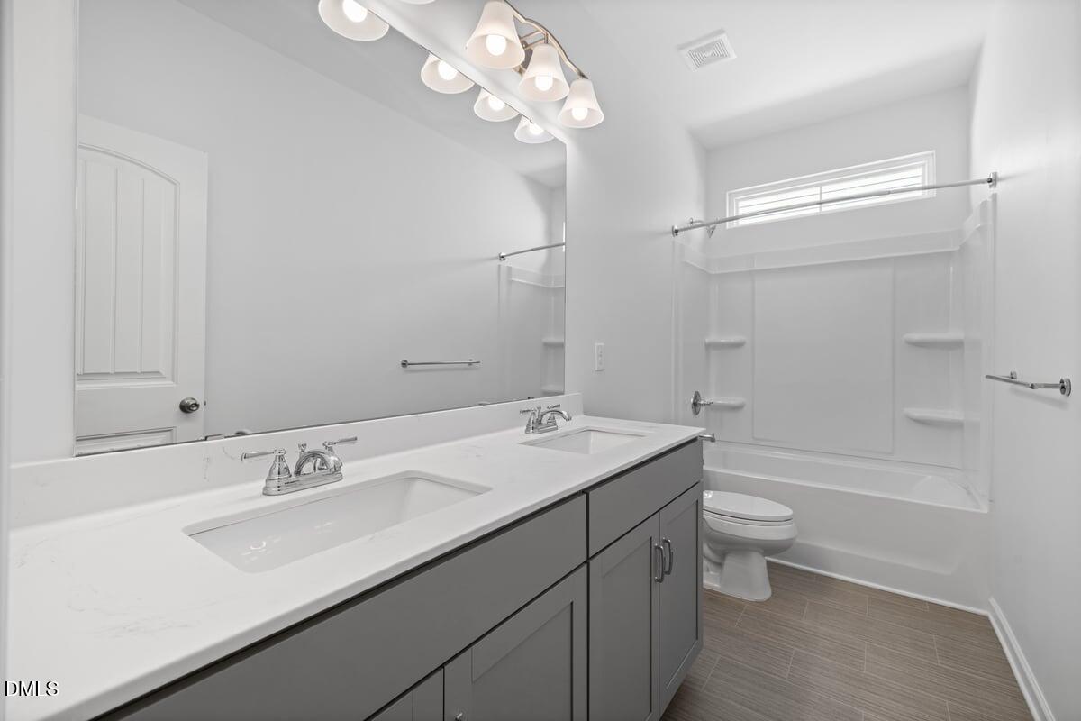 3616 Cross Timber Lane Raleigh, NC 27603 - Photo 26 of 39 a bathroom with a sink a toilet a mirror and shower