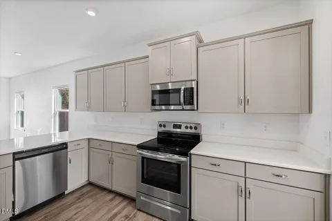 a kitchen with granite countertop white cabinets and white appliances