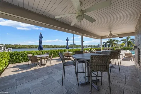 a view of a patio with a table chairs and a backyard