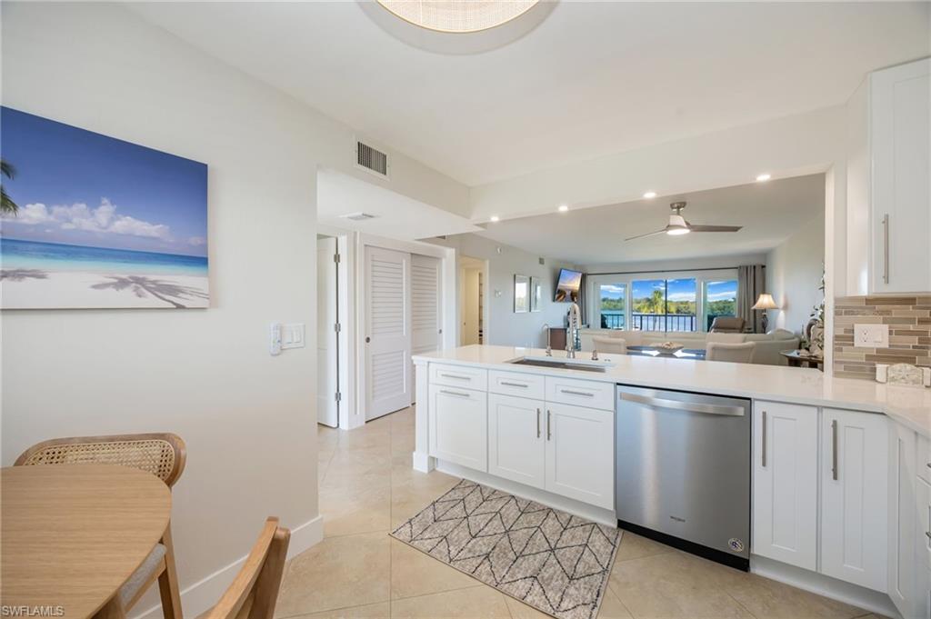 309 Goodlette-Frank Road, Unit A406 Naples, FL 34102 - Photo 6 of 20 a kitchen with white cabinets and sink