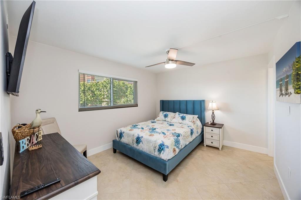 309 Goodlette-Frank Road, Unit A406 Naples, FL 34102 - Photo 9 of 20 a bedroom with a bed and a chandelier