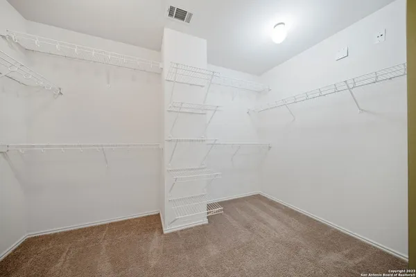 an empty room with windows and ceiling fan