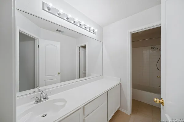 an empty room with windows and ceiling fan
