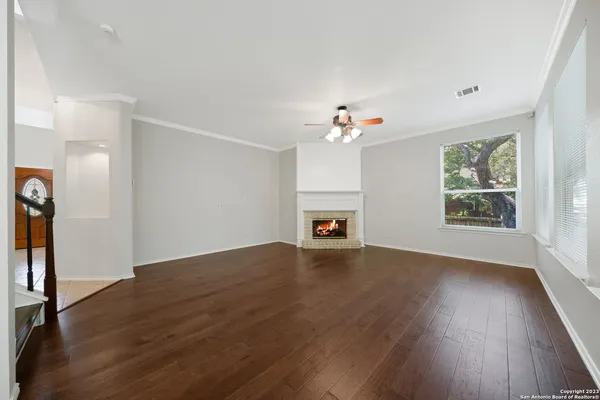 a view of an empty room with window and fire place