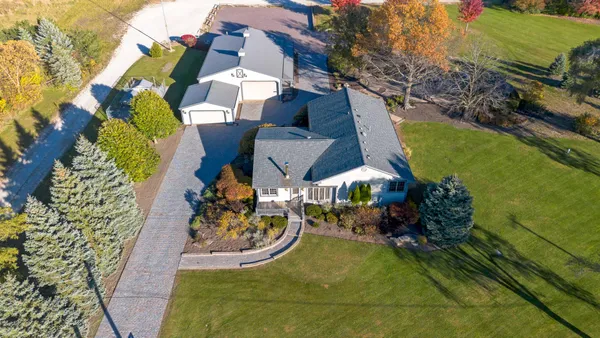an aerial view of a house with a garden and trees