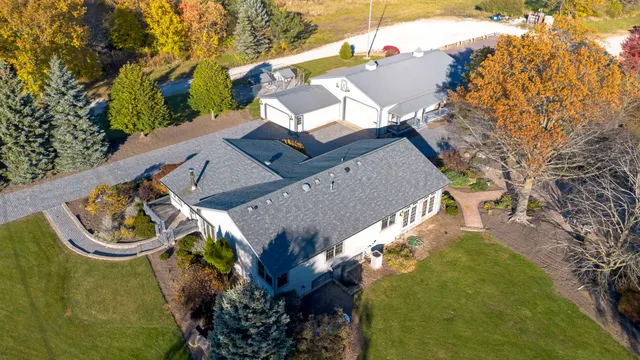 an aerial view of a house with swimming pool and outdoor seating