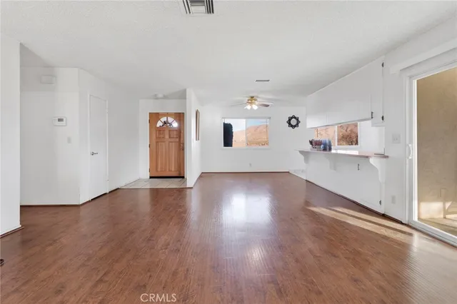 a view of a kitchen with wooden floor and electronic appliances