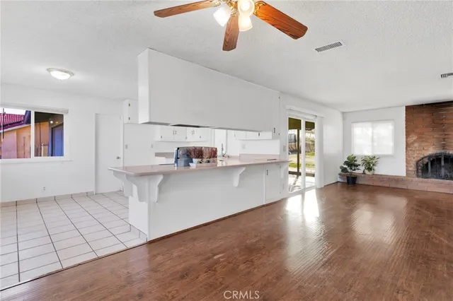 a view of a kitchen with a sink dishwasher a stove top oven with wooden floor