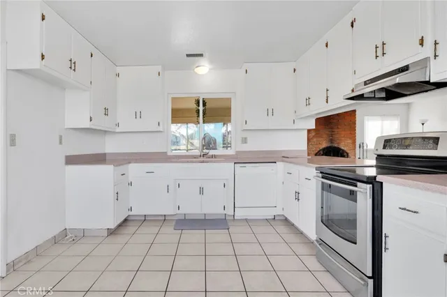 a kitchen with white cabinets stainless steel appliances and a sink