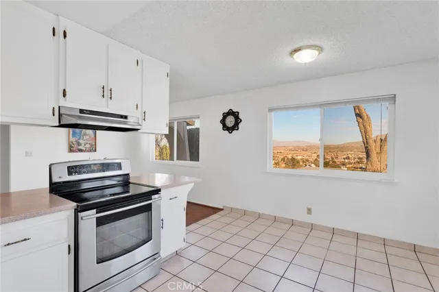 a kitchen with granite countertop a stove and a microwave
