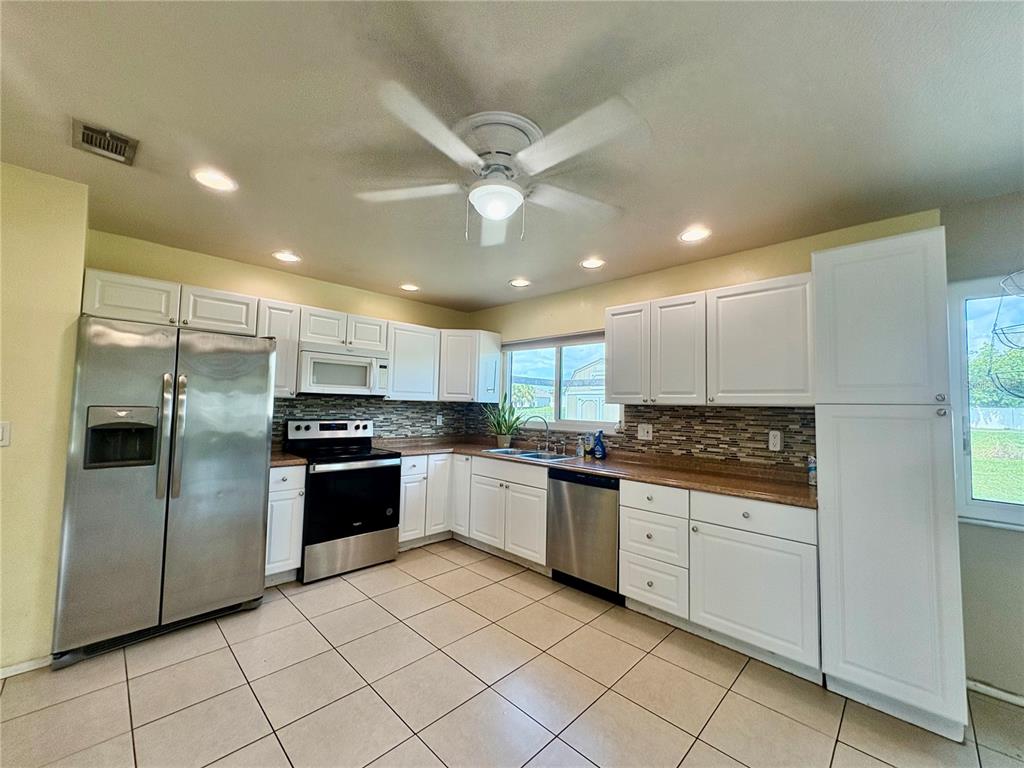 2755 Greendale Road North Port, FL 34287 - Photo 10 of 43 a kitchen with stainless steel appliances kitchen island granite countertop a stove sink and cabinets