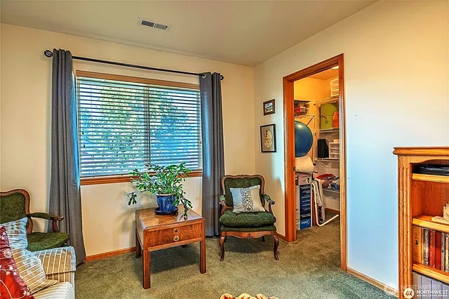 a view of a workspace with furniture and a window
