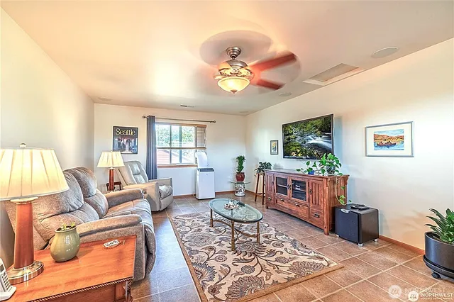 a living room with furniture a flat screen tv and kitchen view