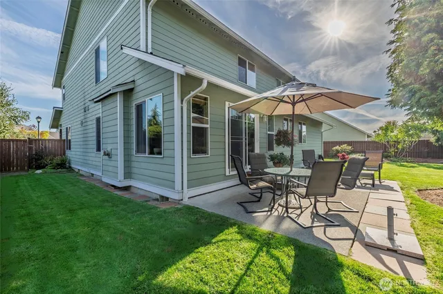 a view of a patio with table and chairs under an umbrella
